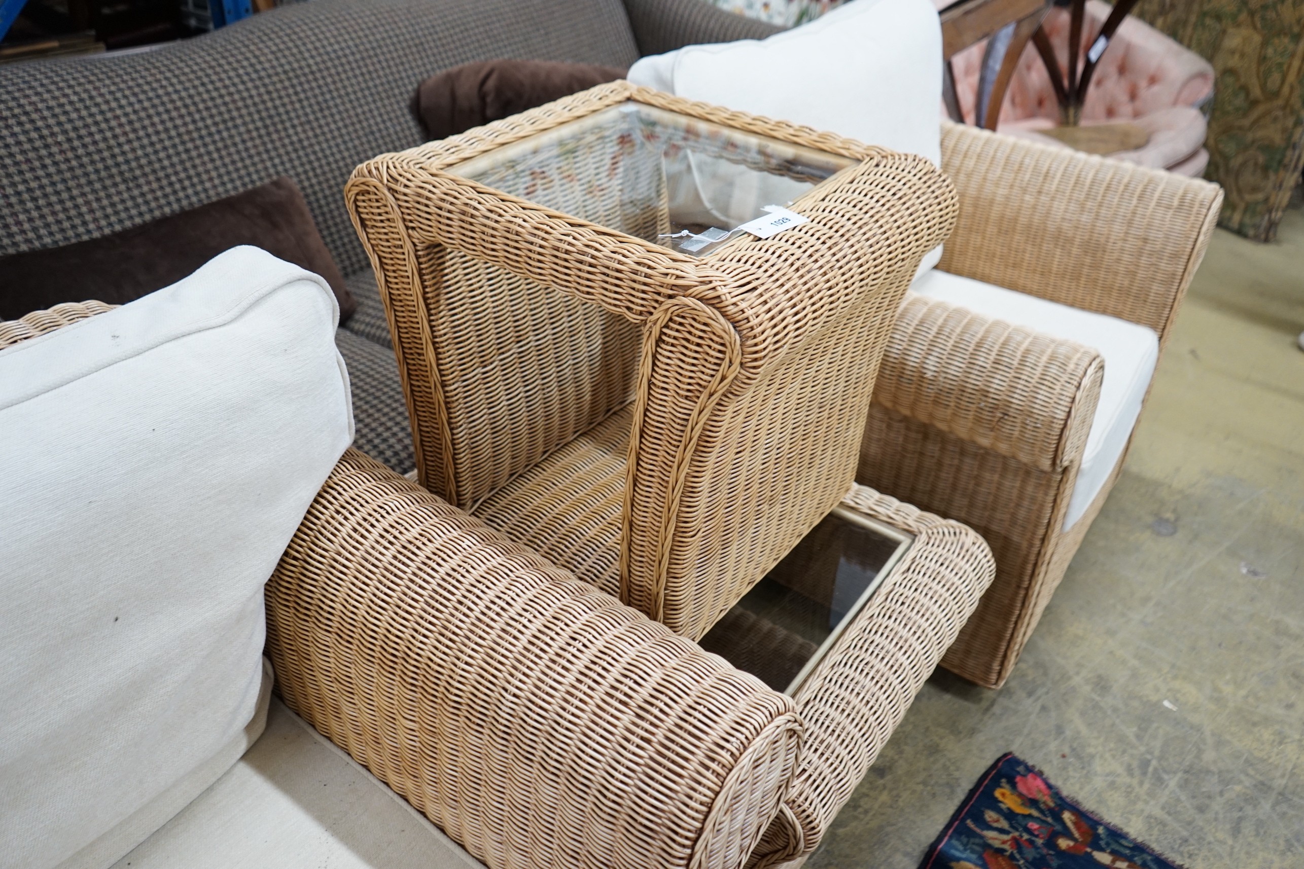 A contemporary rattan and natural fabric four piece conservatory suite, comprising settee, length 180cm, depth 86cm, height 85cm, armchair and two glass top tables